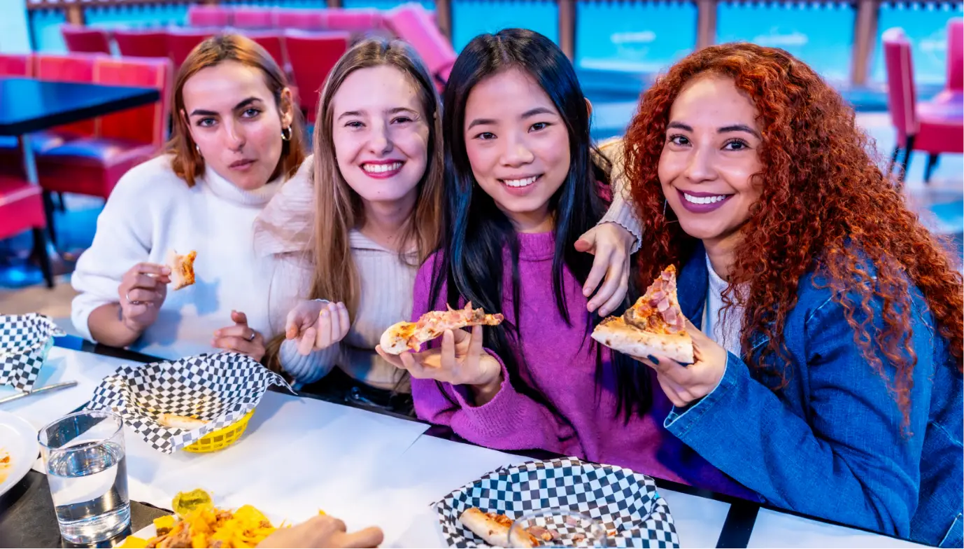 cheerful multiethnic female friends enjoying pizza